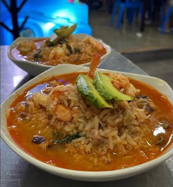 Plato hondo con caldo rojo, arroz, camarón y aguacate
